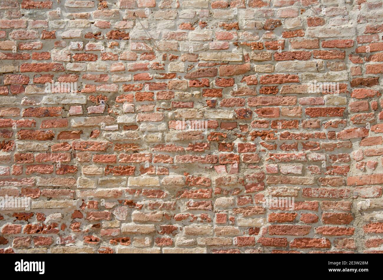 Old red grungy brick wall gives a harmonic structure Stock Photo