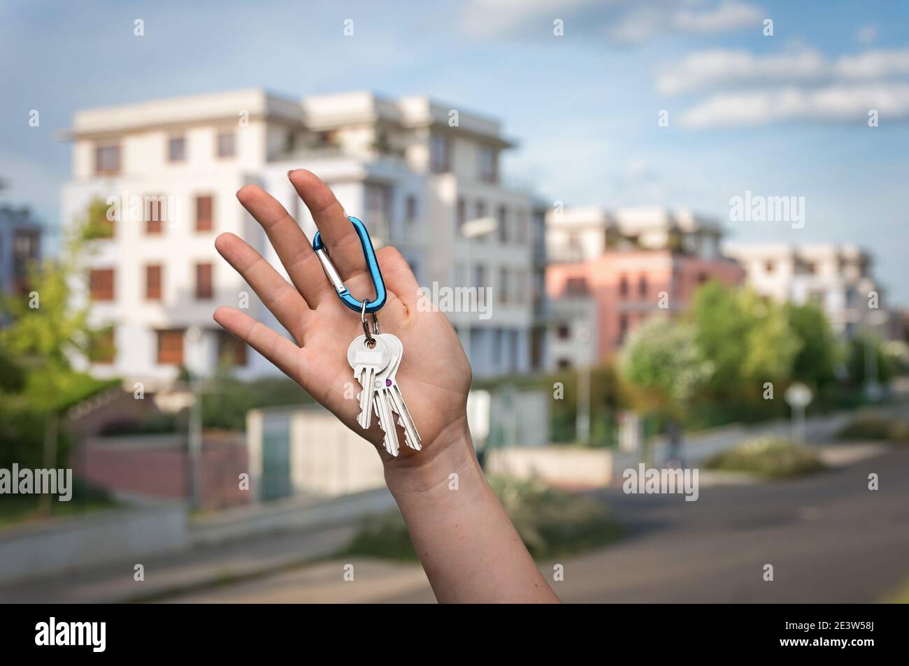 Real estate agent giving house keys to a new property owner on blurred ...