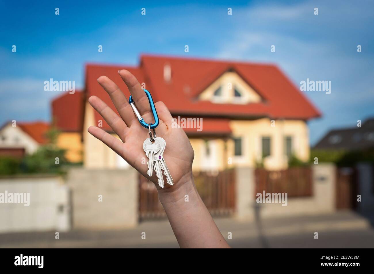 Real estate agent giving house keys to a new property owner on blurred ...