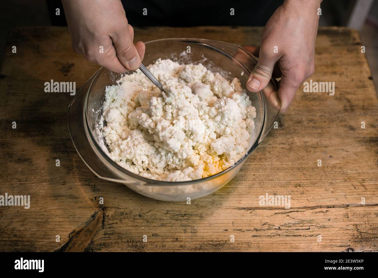 Stirring curd with chicken eggs. Cooking casseroles. Stock Photo