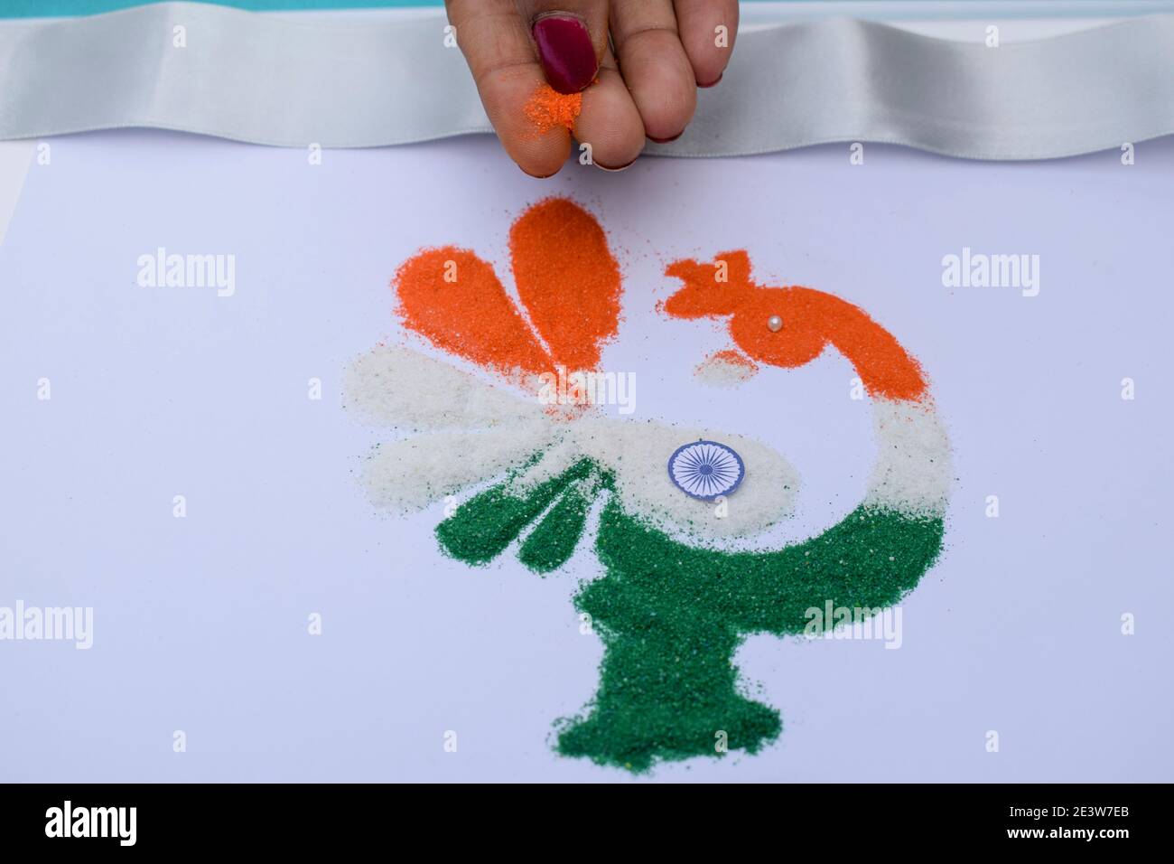 Female making rangoli design of tricolored design saffron white and ...