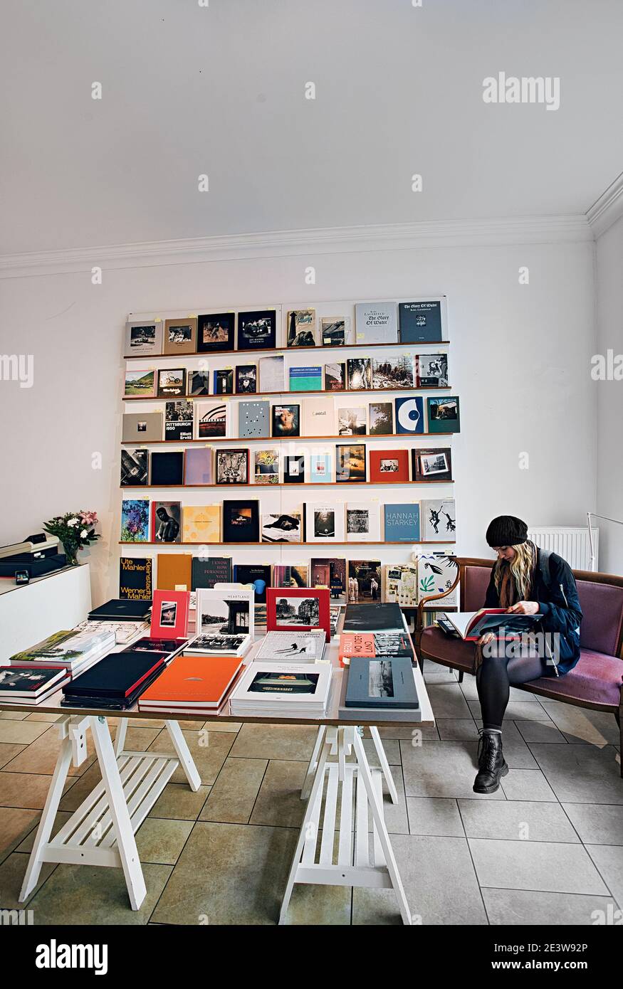 GERMANY / Berlin /Bookstores/ Woman reading a book at photography book