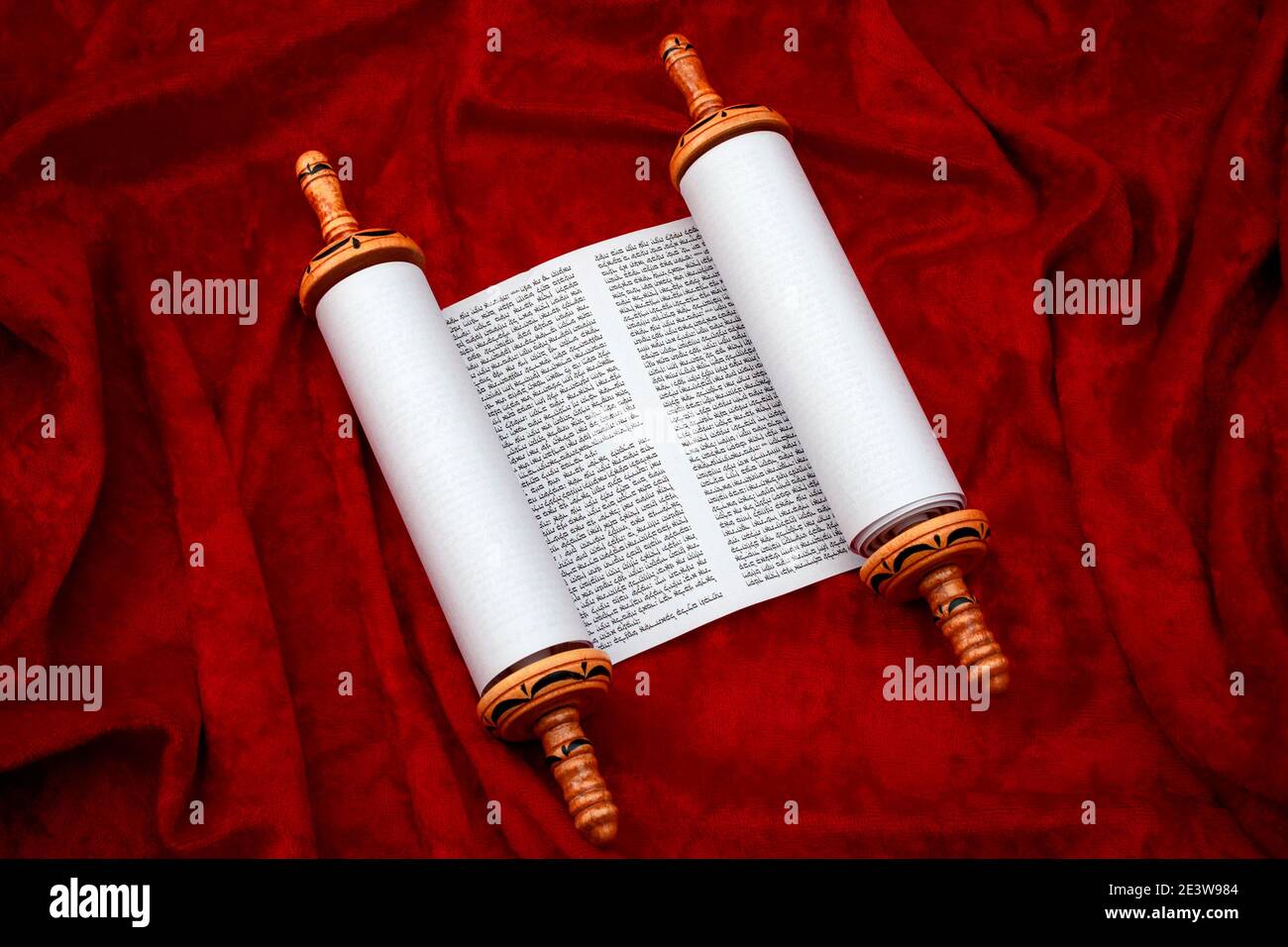 The Old Testament text, Jewish temple or synagogue, religious parchment scroll and the Judaic religion concept theme with the holy Torah open on red v Stock Photo