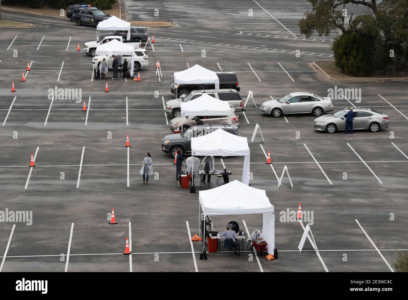 Round Rock, USA. 20th Jan, 2021. Central Texans line up in their cars for drive-through COVID-19 vaccinations after several thousand doses of the Moderna product were delivered. The clinic, set up in a high school football stadium parking lot, handled almost 2,000 vaccinations on its first day. Credit: Bob Daemmrich/Alamy Live News Stock Photo
