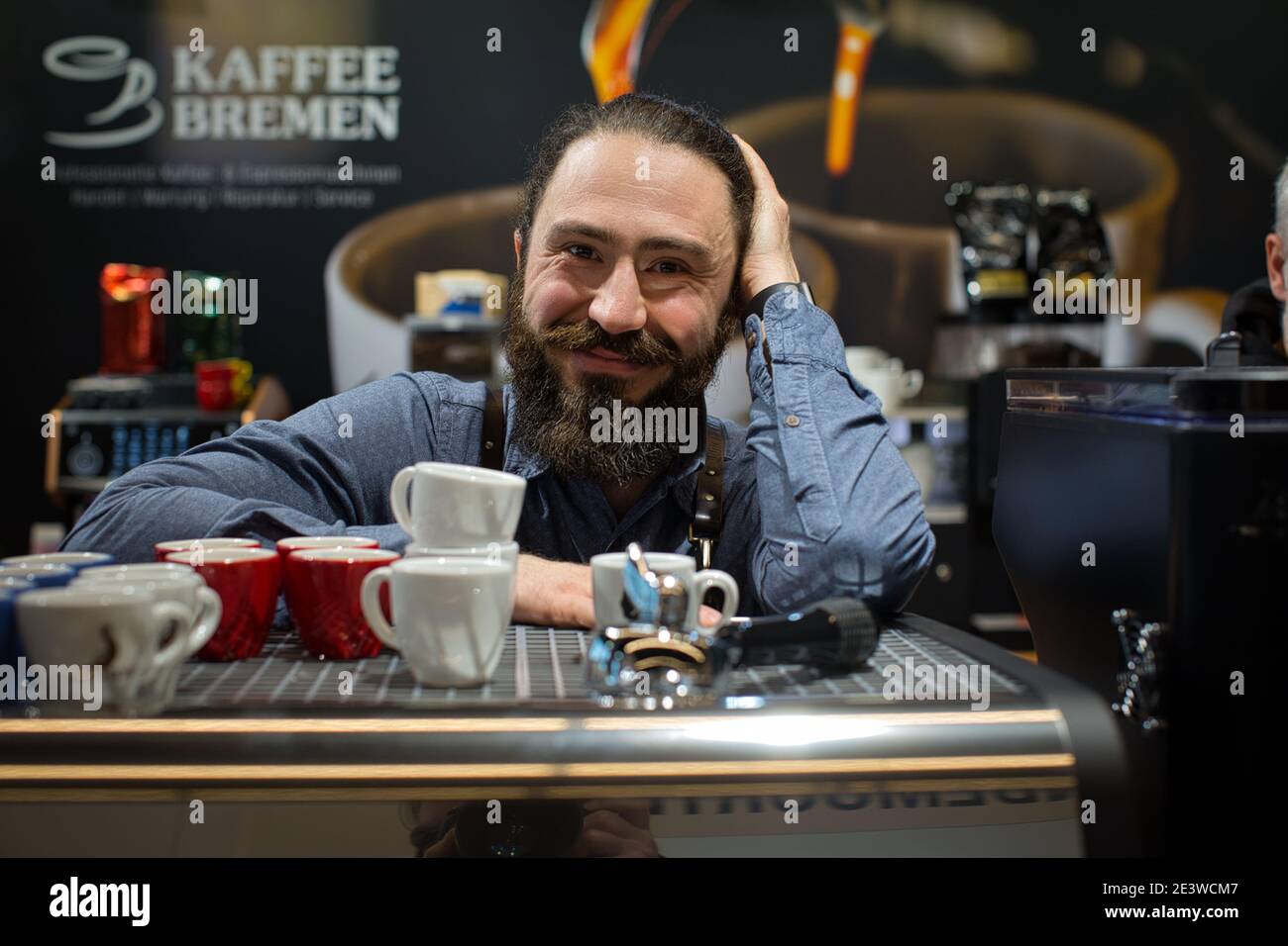 Portrait of smiling Barista with coffee equipment, espresso coffee machine, coffee grinder, cups for making drinks Stock Photo