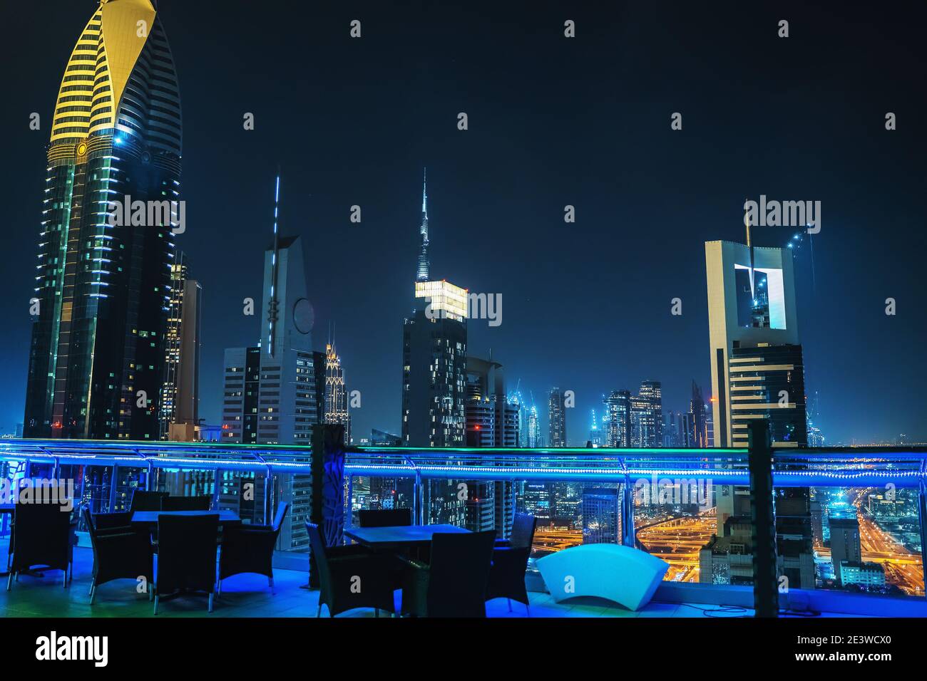Dubai downtown night view from rooftop and empty restaurant tables on foreground, UAE, luxurious travel and tourism. Stock Photo