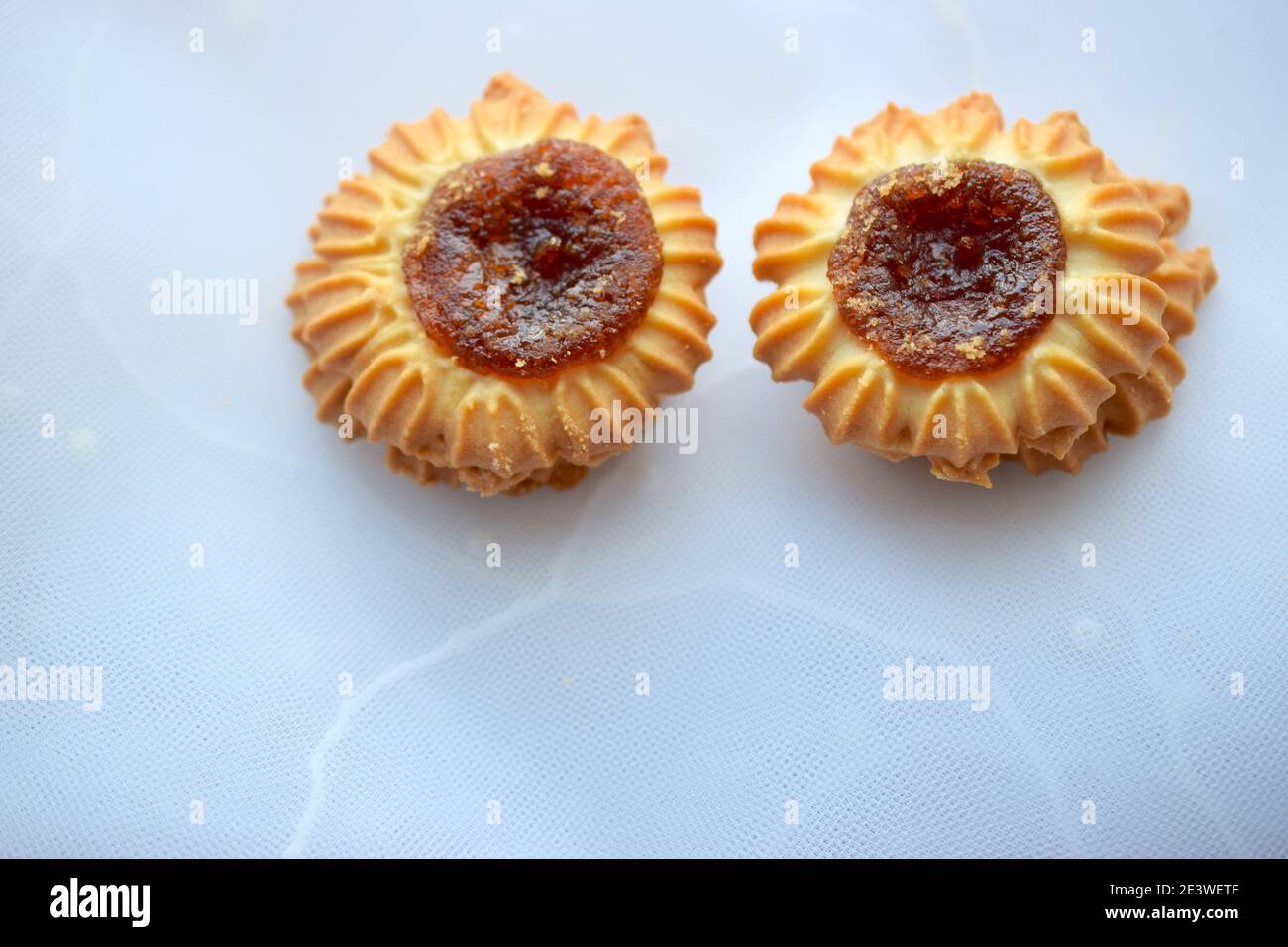 Round cookies with jam on light texture. Stock Photo