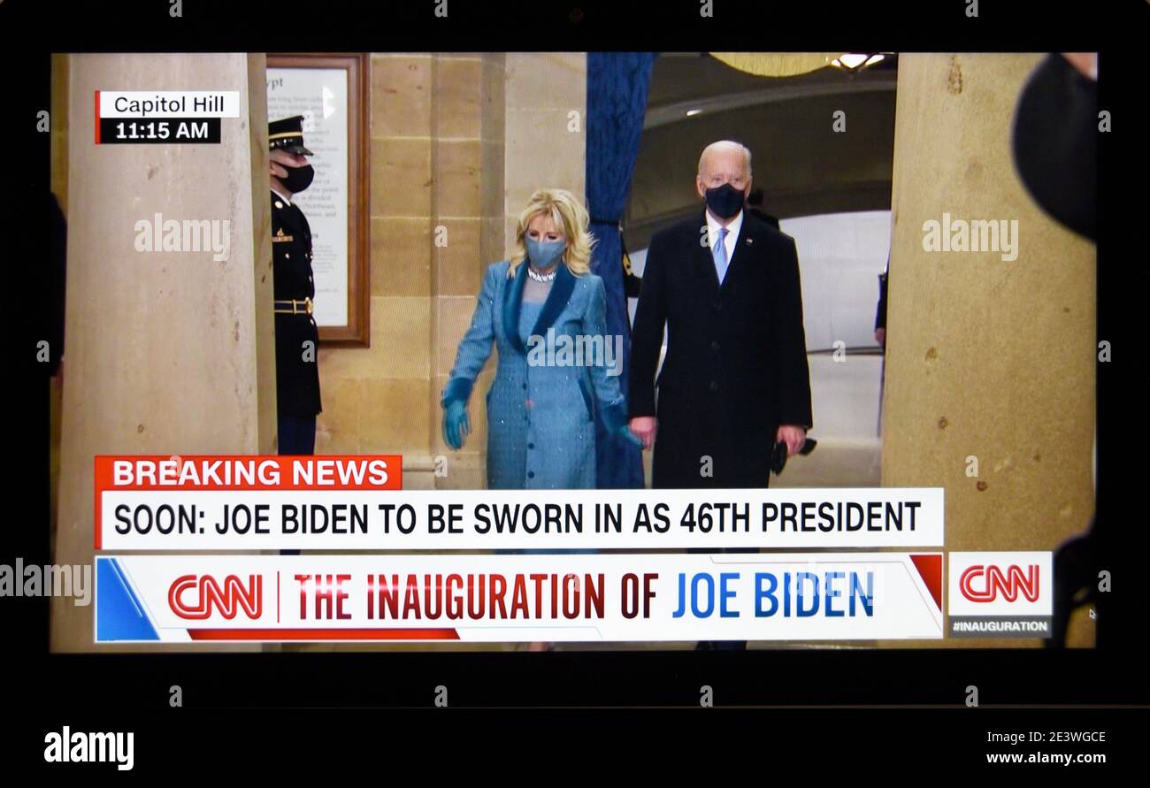 A CNN television screen shot of U.S. President Joe Biden walking with wife, Jill Biden, in the Capitol Building at Biden's inauguration in 2021. Stock Photo