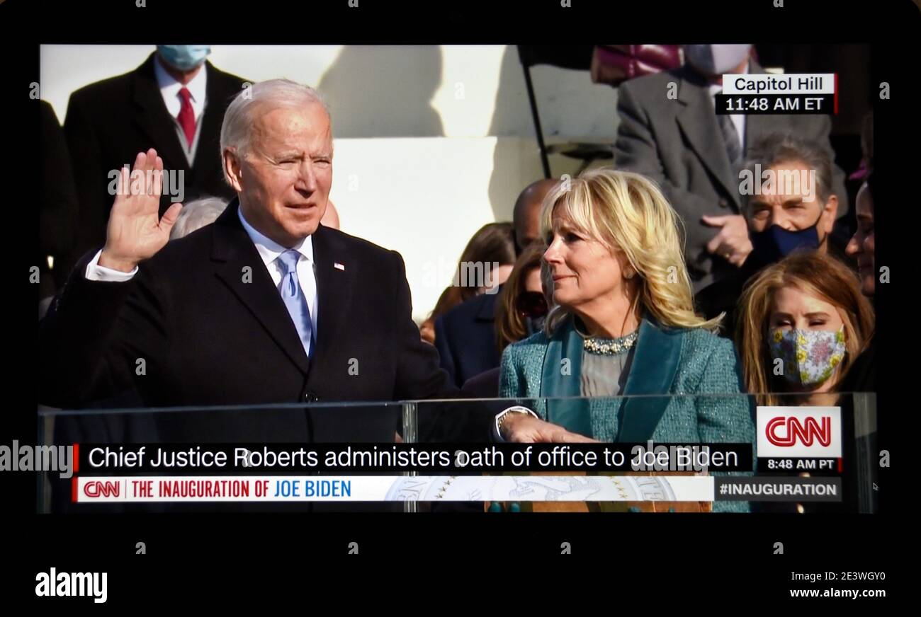 A CNN television screen shot of U.S. President Joe Biden being sworn in at his 2021 inauguration in Washington, D.C. with his wife, Dr. Jill Biden. Stock Photo