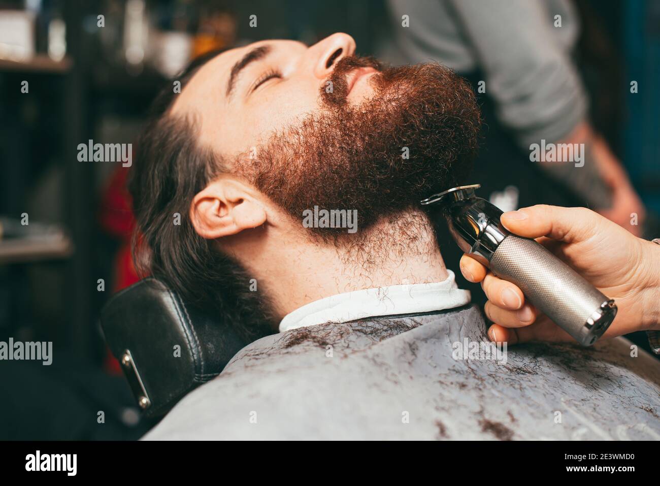 Man at salon, barber working on beard haircut Stock Photo