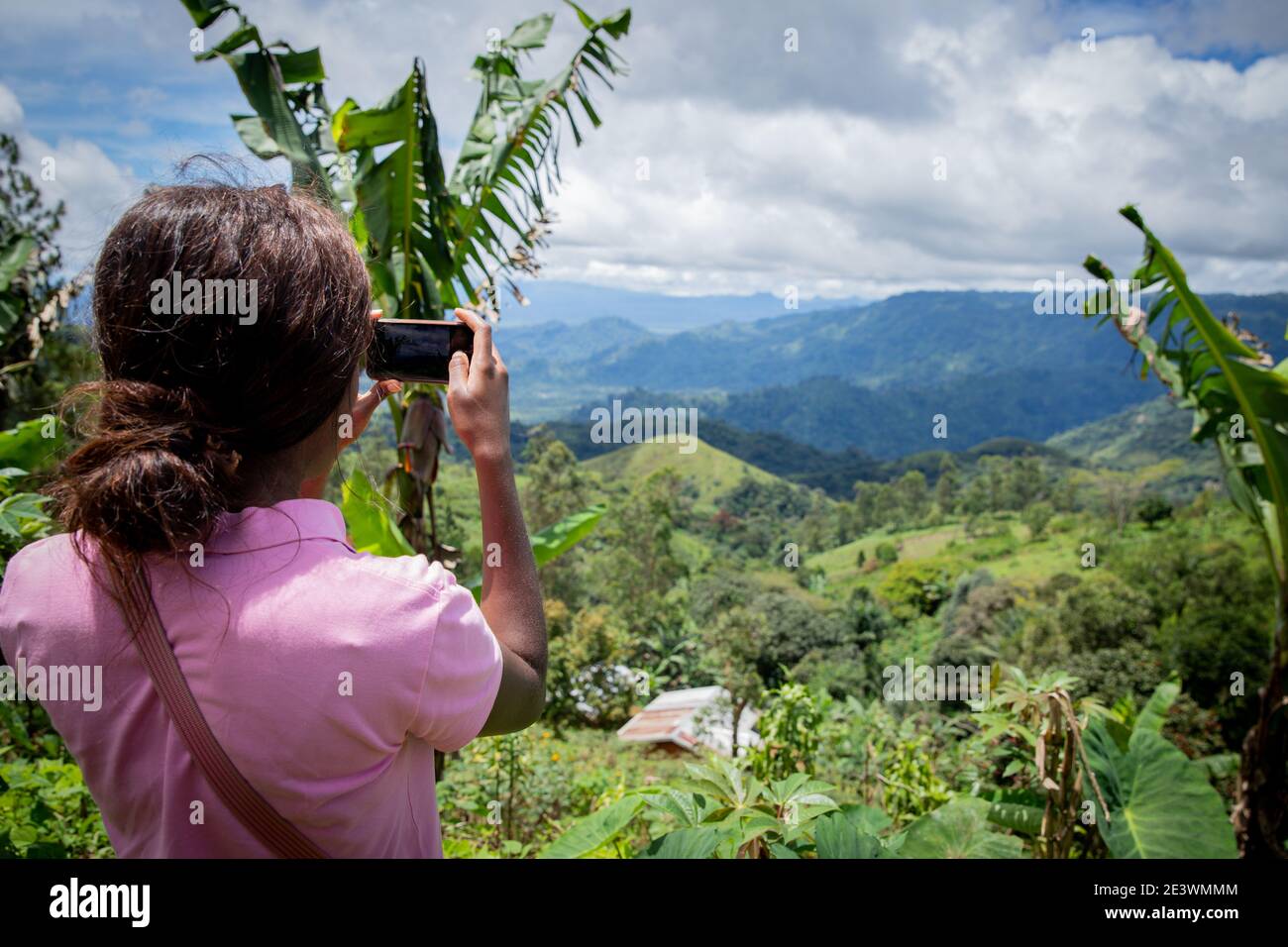 A tourist takes a picture with her smartphone of a beautiful african landscape to share it on social networks Stock Photo