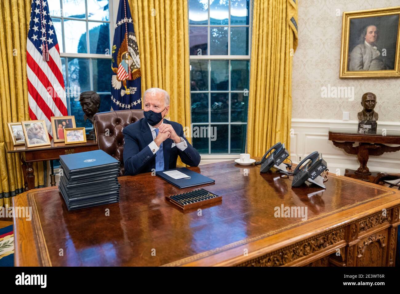 United States President Joe Biden signs executive order on Covid-19 during his first minutes in the Oval Office, Wednesday, Jan. 20, 2021. President Biden as the 46th president of the United States. Credit: Doug Mills/Pool via CNP | usage worldwide Stock Photo