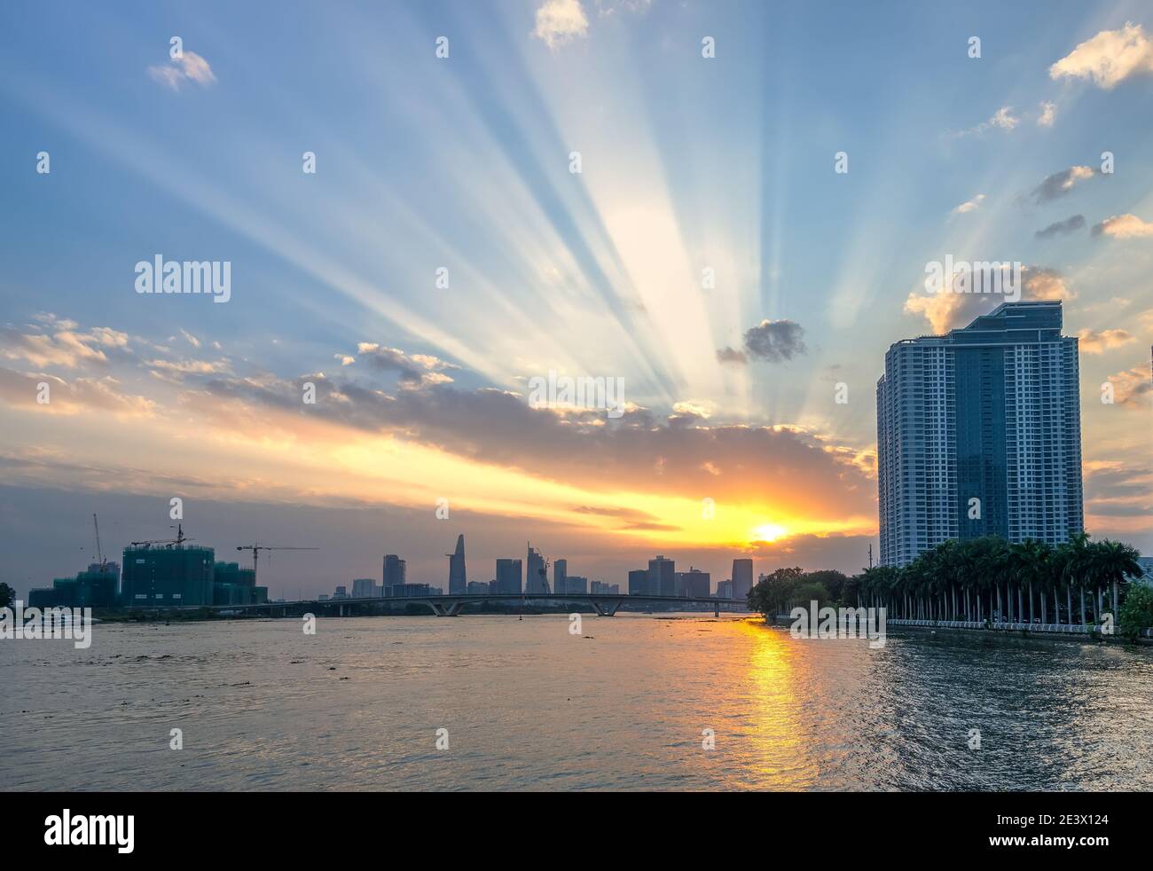 Sunset in urban areas along river with skyscrapers read shine by sky dramatic create beauty of urban development in Ho Chi Minh City, Vietnam Stock Photo