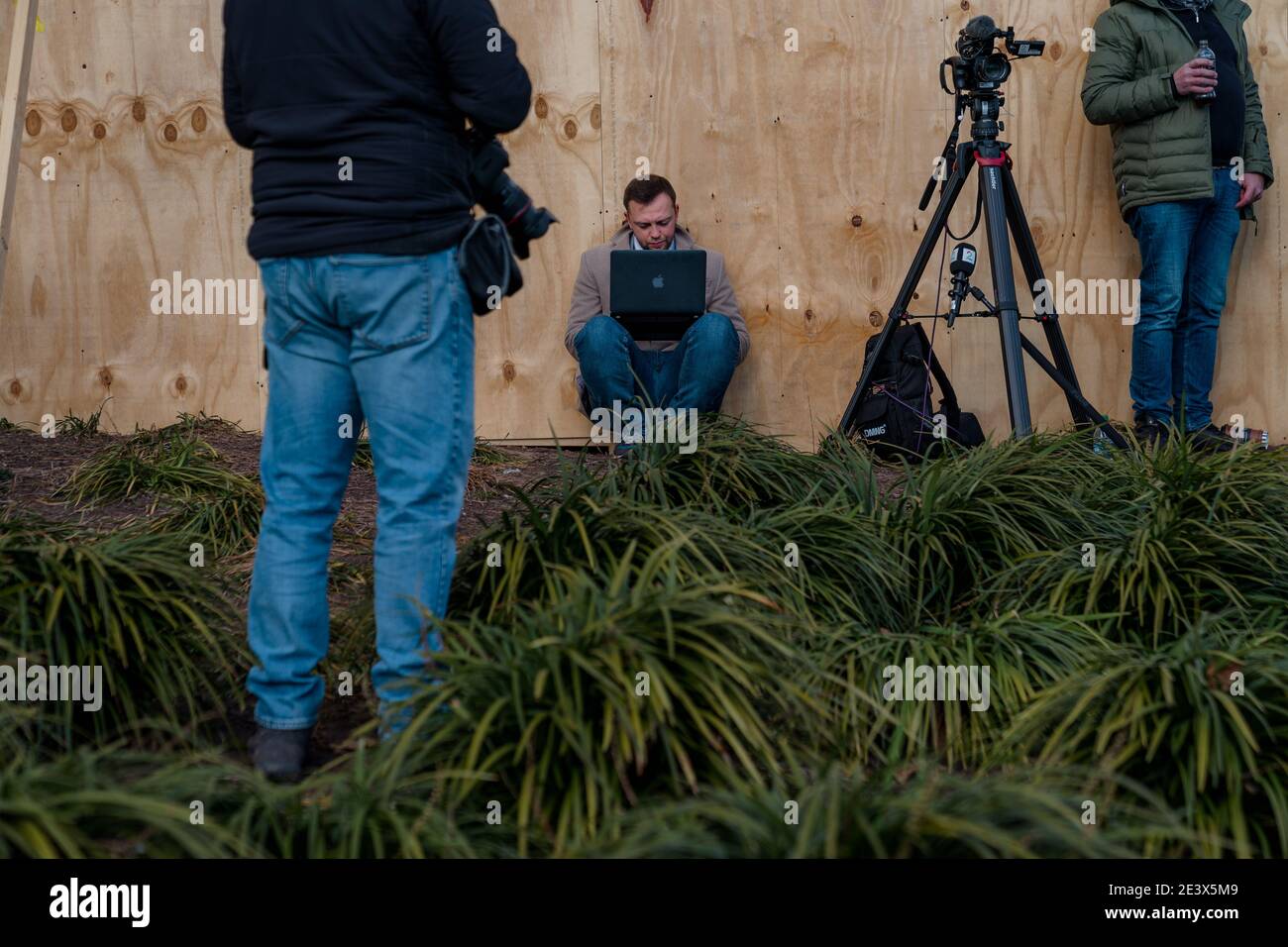 Washington, District of Columbua, USA. 20th Jan, 2021. A member of the press works on their laptop while sitting in a landscaped area during inauguration day. Credit: Jungho Kim/ZUMA Wire/Alamy Live News Stock Photo