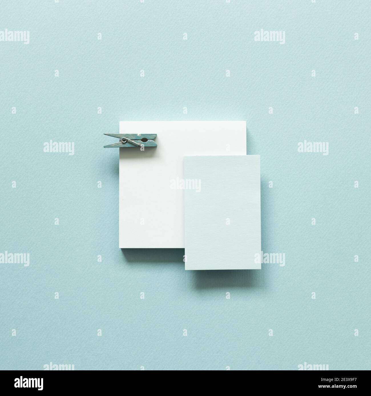 Blue memo pad with wooden clip on blue background. top view, copy space Stock Photo