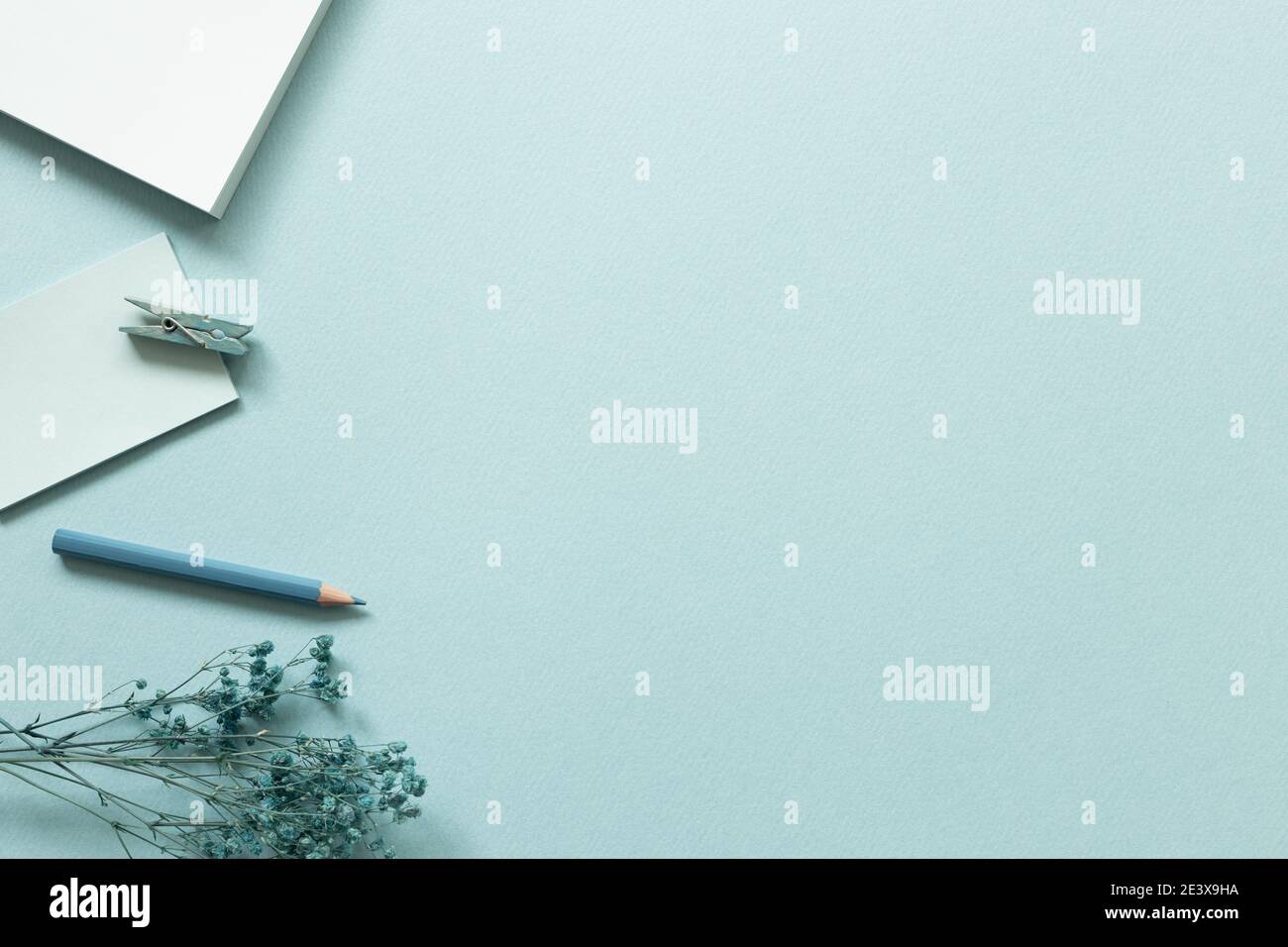 Work and study place. Notepad, colored pencil, clip on blue background. flat lay, top view, copy space Stock Photo