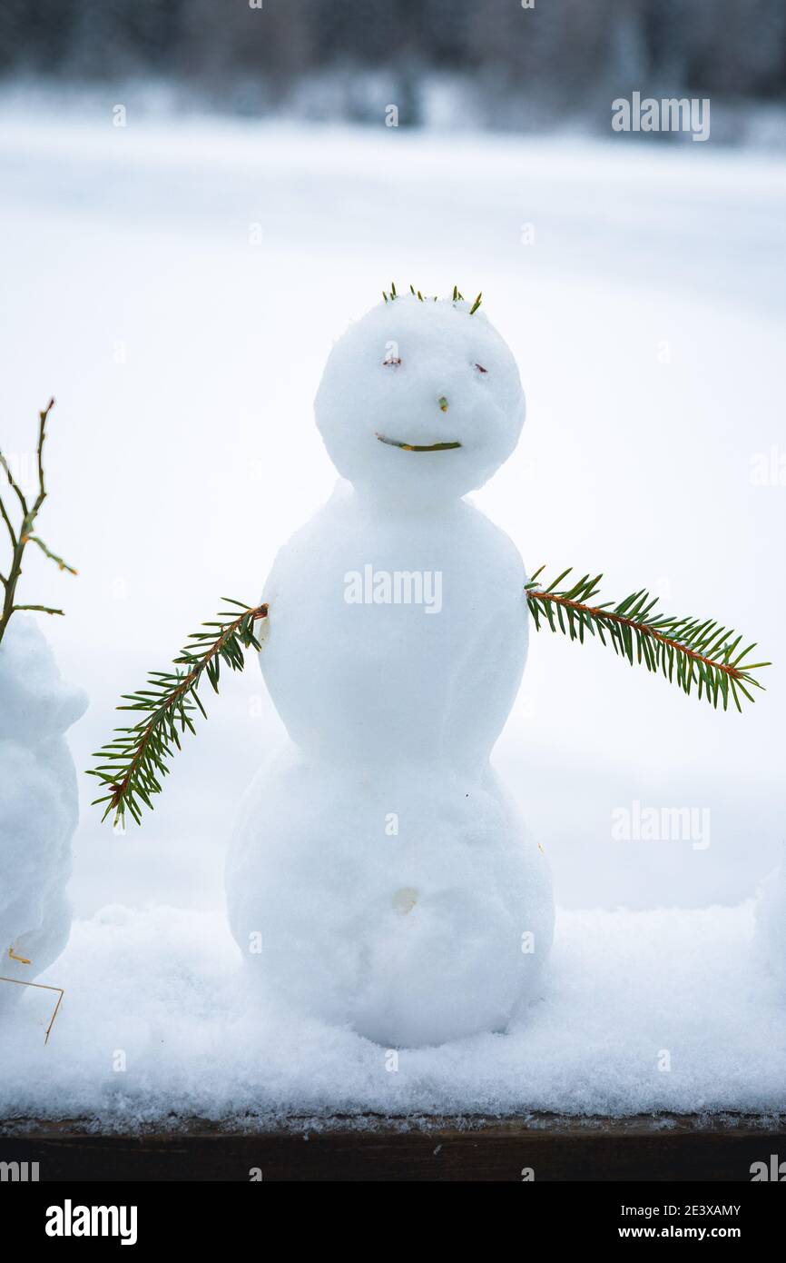 A Small Snowman With A Frozen Lake In The Background Stock Photo Alamy