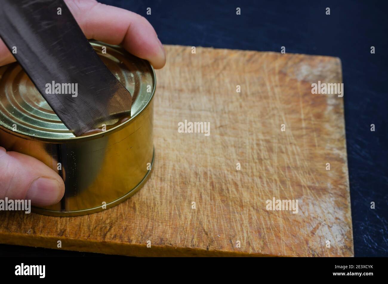 Canned food, shelf life food concept. Closeup of male hands opening a