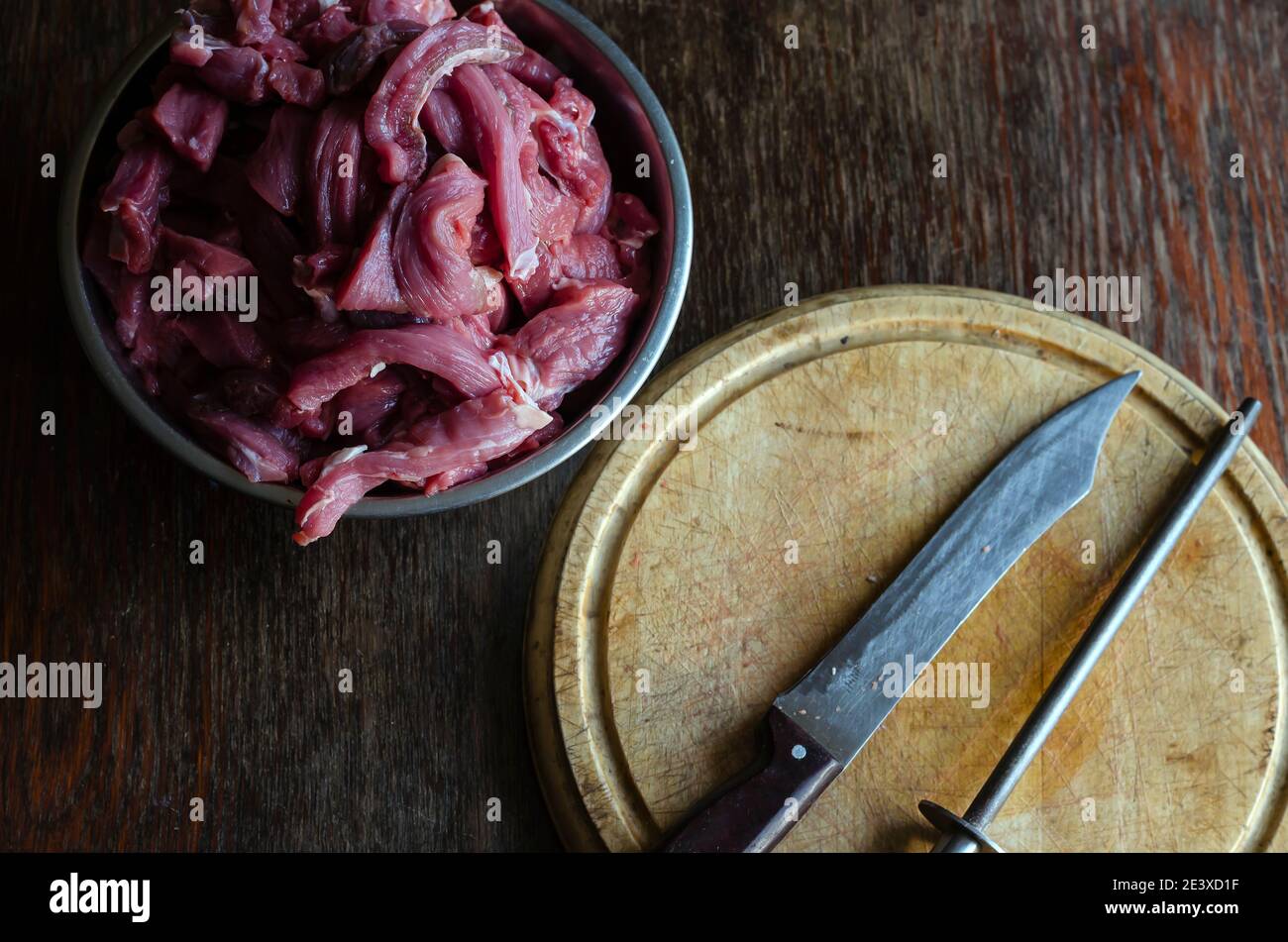 https://c8.alamy.com/comp/2E3XD1F/cooking-beef-meat-dishes-a-portion-of-raw-meat-for-beef-stroganoff-in-a-metal-bowl-cutting-board-knife-mussat-2E3XD1F.jpg