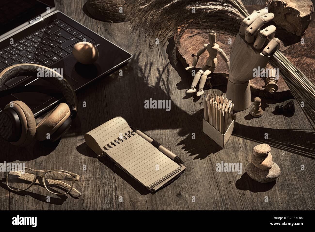 Creative writing concept, vintage look. Open block note. Glasses, laptop, leather earphones. Surreal decor. Chess figures, hand model with dry grass Stock Photo