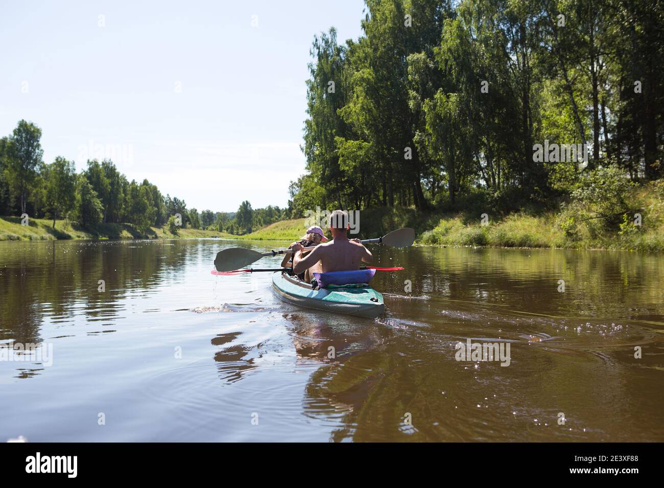 A couple of men and women kayak on the river in the summer. Active recreation, family travel, extreme adventure, sports and ecological domestic touris Stock Photo