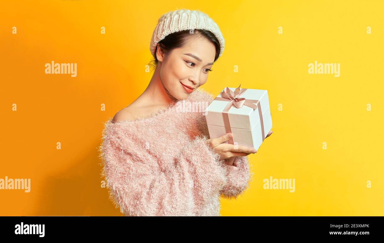 Pretty young asian woman in cute casual attire holding pink pastel presents with joyfully.Happy new year or Birthday eve celebration concept. Stock Photo