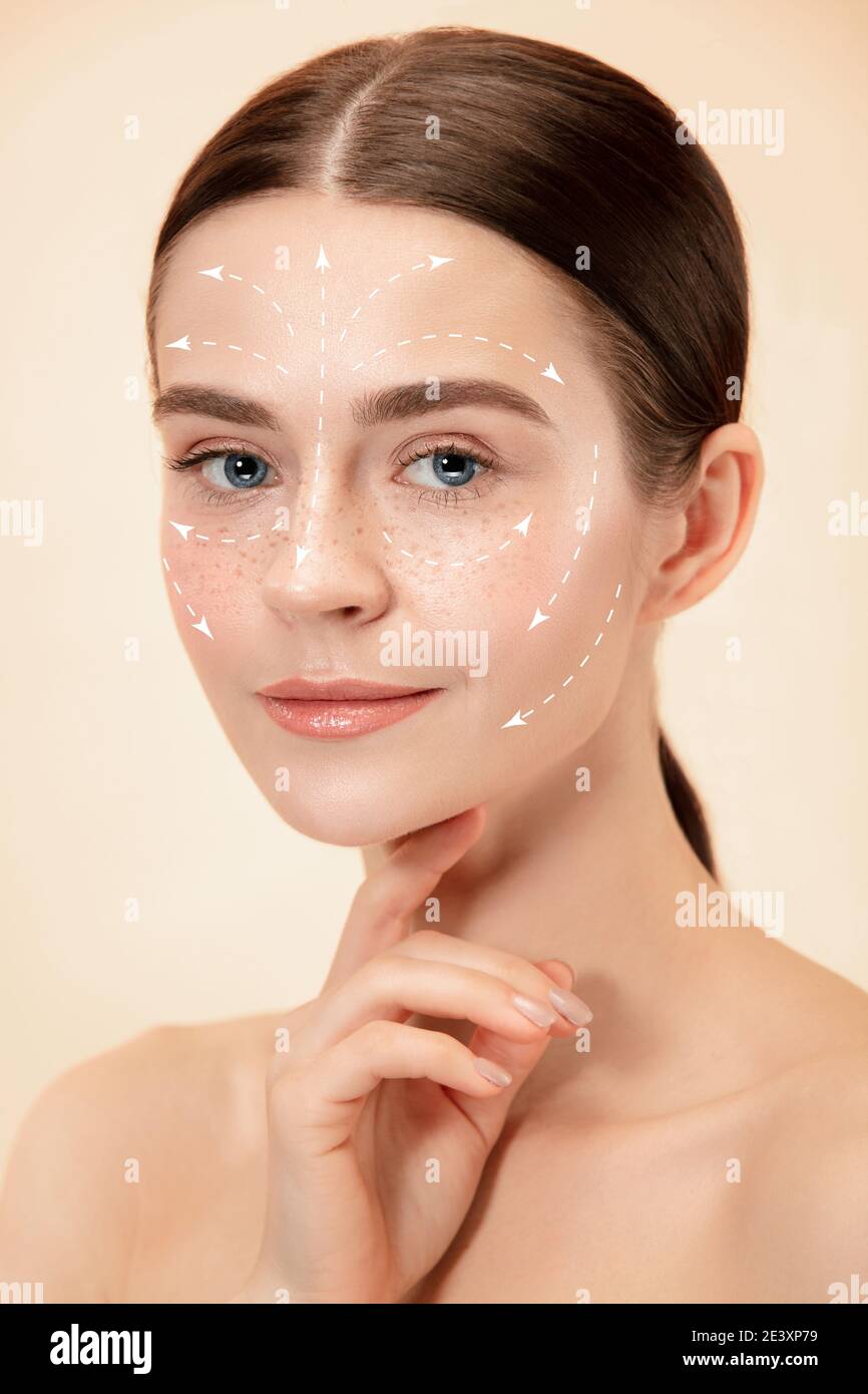Beautiful female face with lifting up arrows isolated on studio background. Concept of bodycare, cosmetics, skincare, correction surgery, beauty and perfect skin. Flyer for your ad. Antiaging. Stock Photo