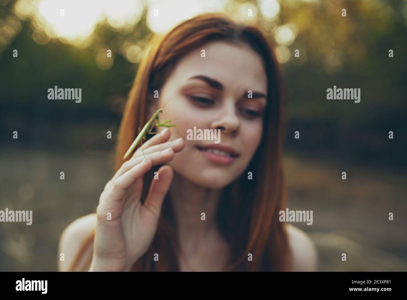 romantic woman with praying mantis on her hand outdoors in the meadow Stock Photo