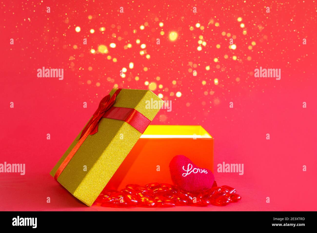 Open red gift box with a bow and a soft heart with the inscription Love ...
