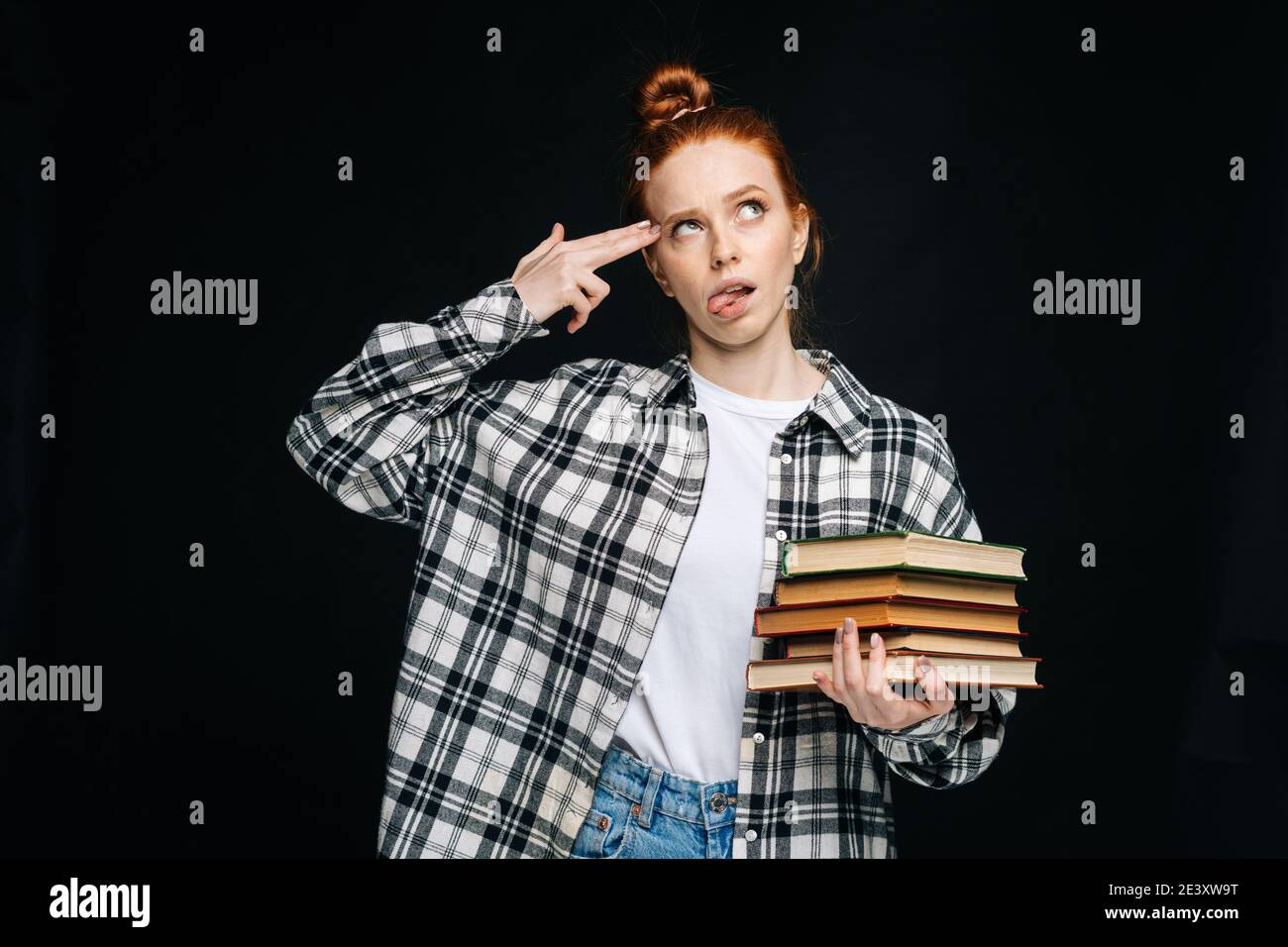 Unhappy young woman student making suicide gesture making gun sign with hand, pointing to head Stock Photo