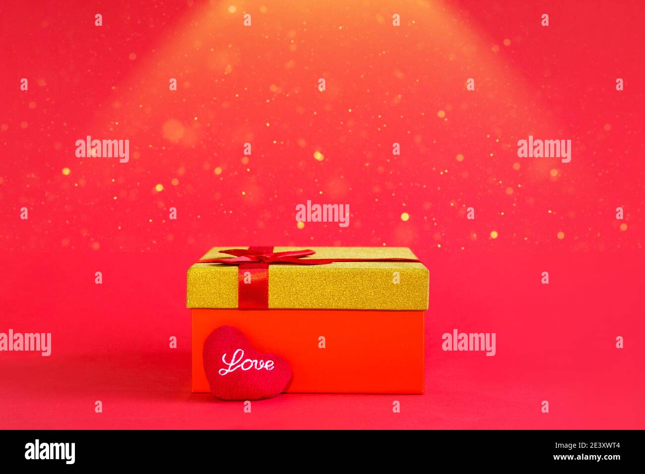 Open red gift box with a bow and a soft heart with the inscription Love ...