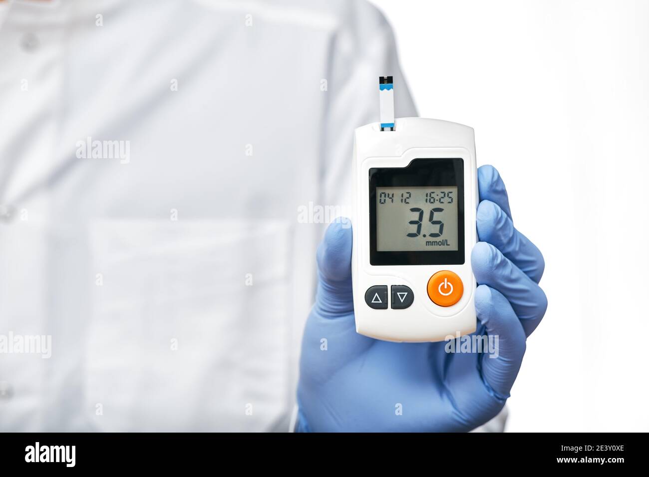 Endocrinologist wearing white coat holding glucometer for measuring glucose levels in the patient's blood, isolated on white background Stock Photo