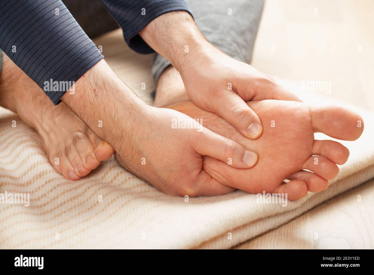 man doing flatfoot correction self massage at home Stock Photo