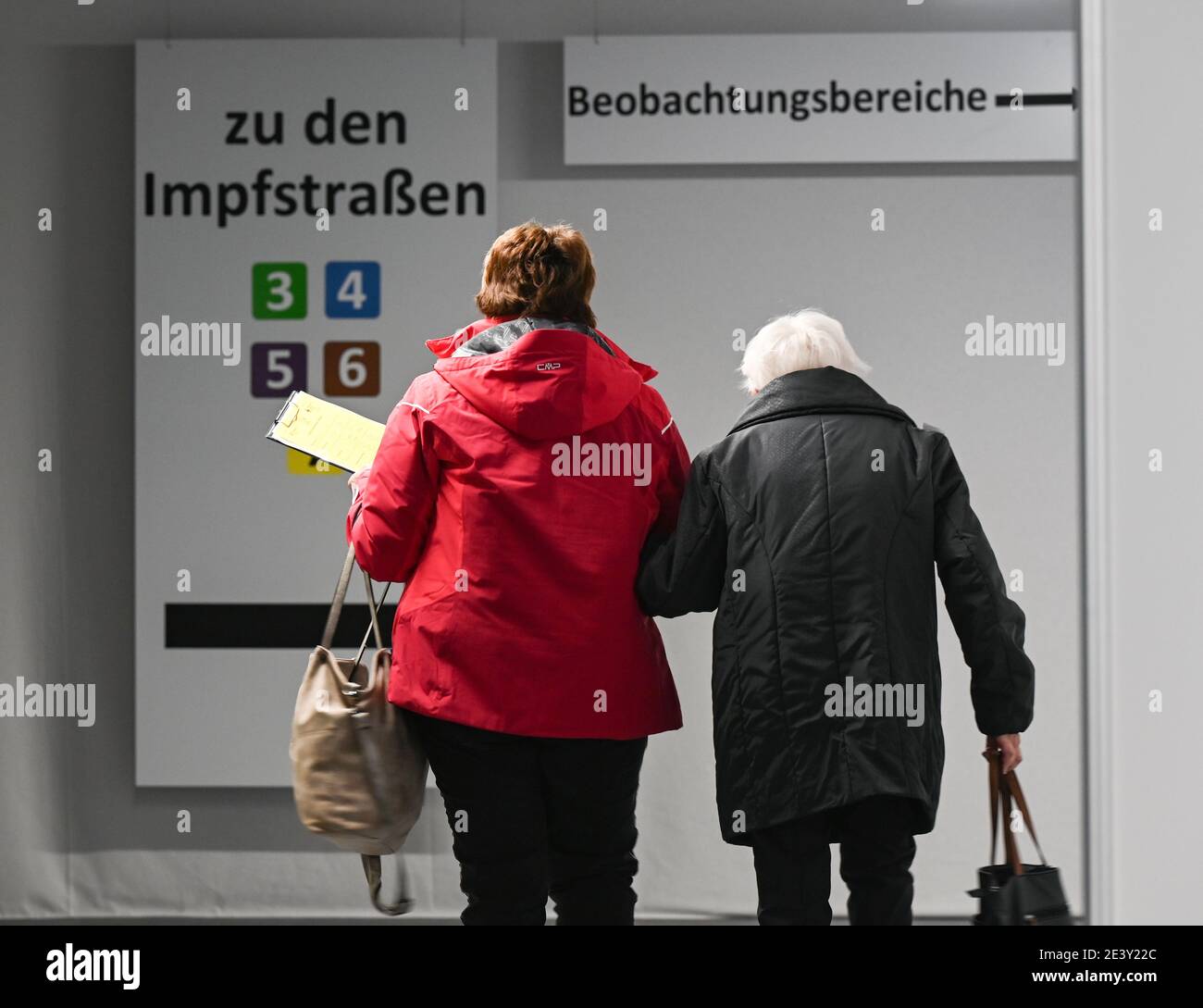 Heuchelheim, Germany. 21st Jan, 2021. An elderly woman (r) is escorted to a vaccination booth at the vaccination center. The first six regional vaccination centres in Hesse have been open since 19 January. Credit: Arne Dedert/dpa/POOL/dpa/Alamy Live News Stock Photo