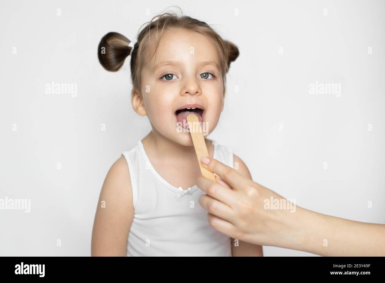 Close up of pretty little child girl with open mouth during a medical