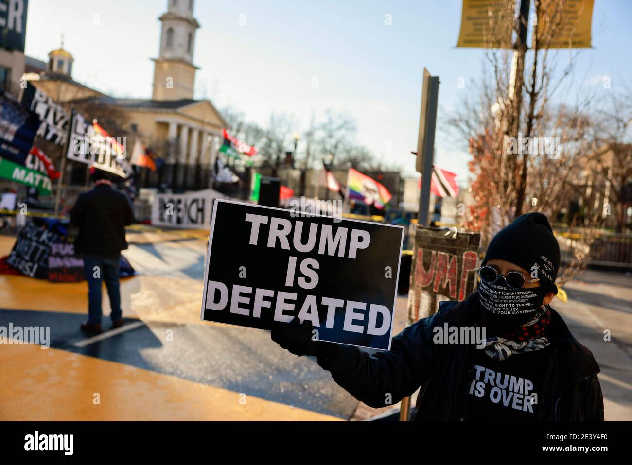 Activist Laurie Arbeiter holds a sign reading, 'Trump is Defeated' at Black Lives Matter Plaza after the departure of Donald J. Trump’s helicopter at the white house on the inauguration day of President Joe Biden and Vice President Kamala Harris. Stock Photo