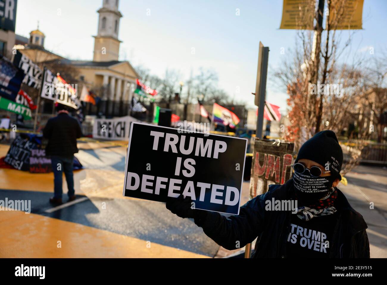 Washington, Columbia, USA. 20th Jan, 2020. Activist Laurie Arbeiter holds a sign reading, ''Trump is Defeated'' at Black Lives Matter Plaza after the departure of Donald J. Trump's helicopter at the white house on the inauguration day of President Joe Biden and Vice President Kamala Harris. Credit: Jeremy Hogan/SOPA Images/ZUMA Wire/Alamy Live News Stock Photo