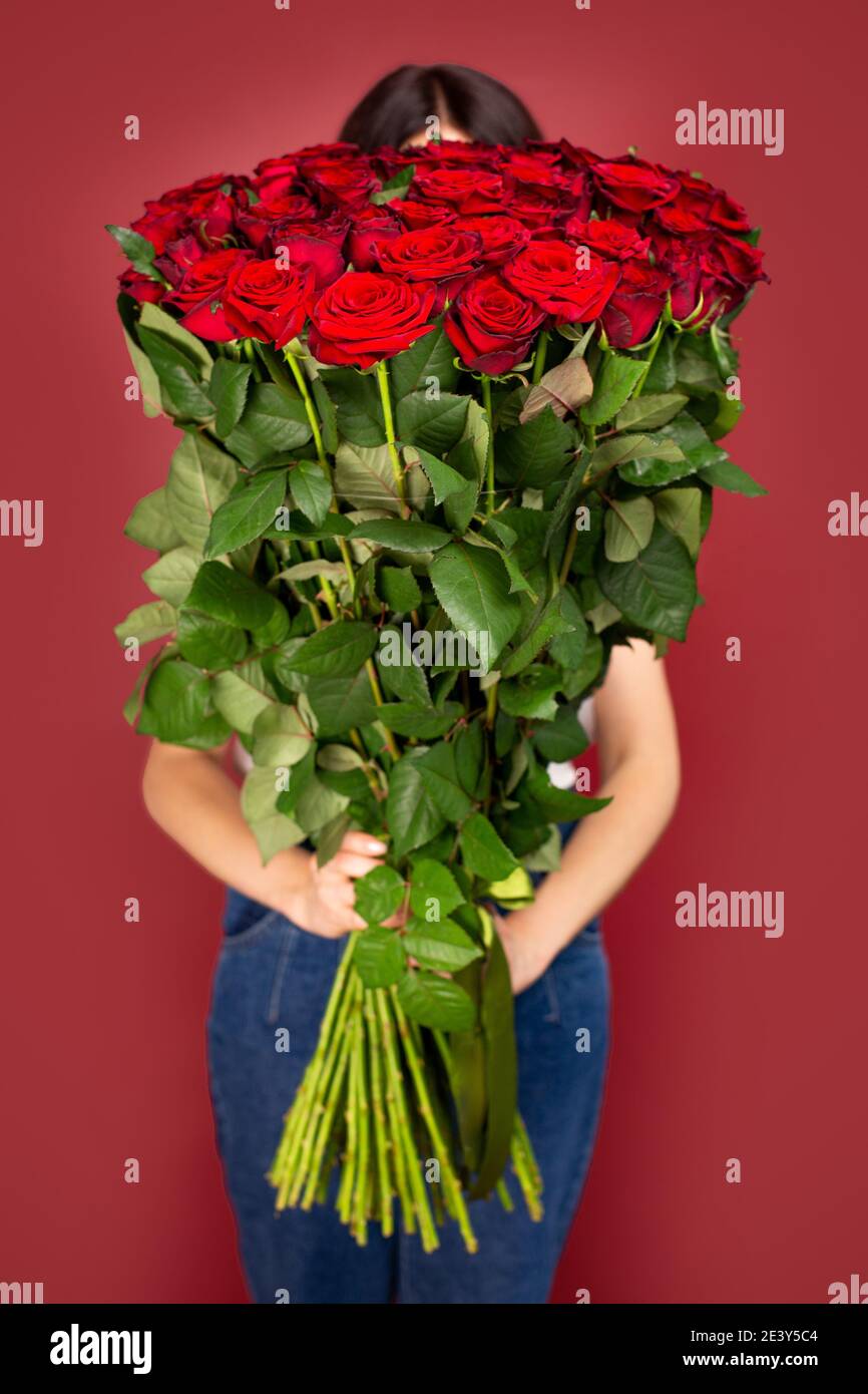 The girl with big bouquet of flowers red roses in front of her Stock ...