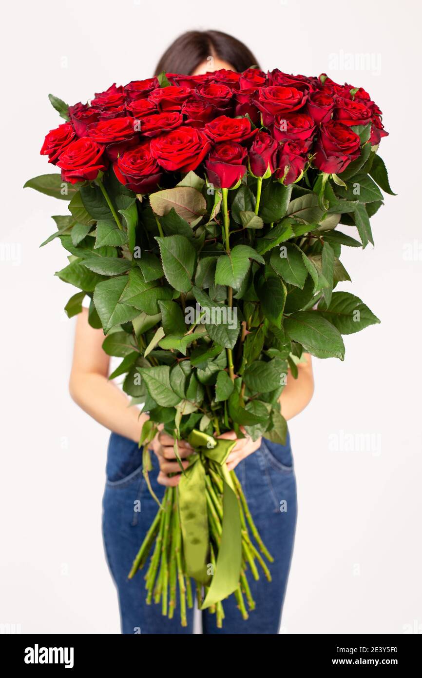 The girl with big bouquet of red roses in front of her Stock Photo - Alamy