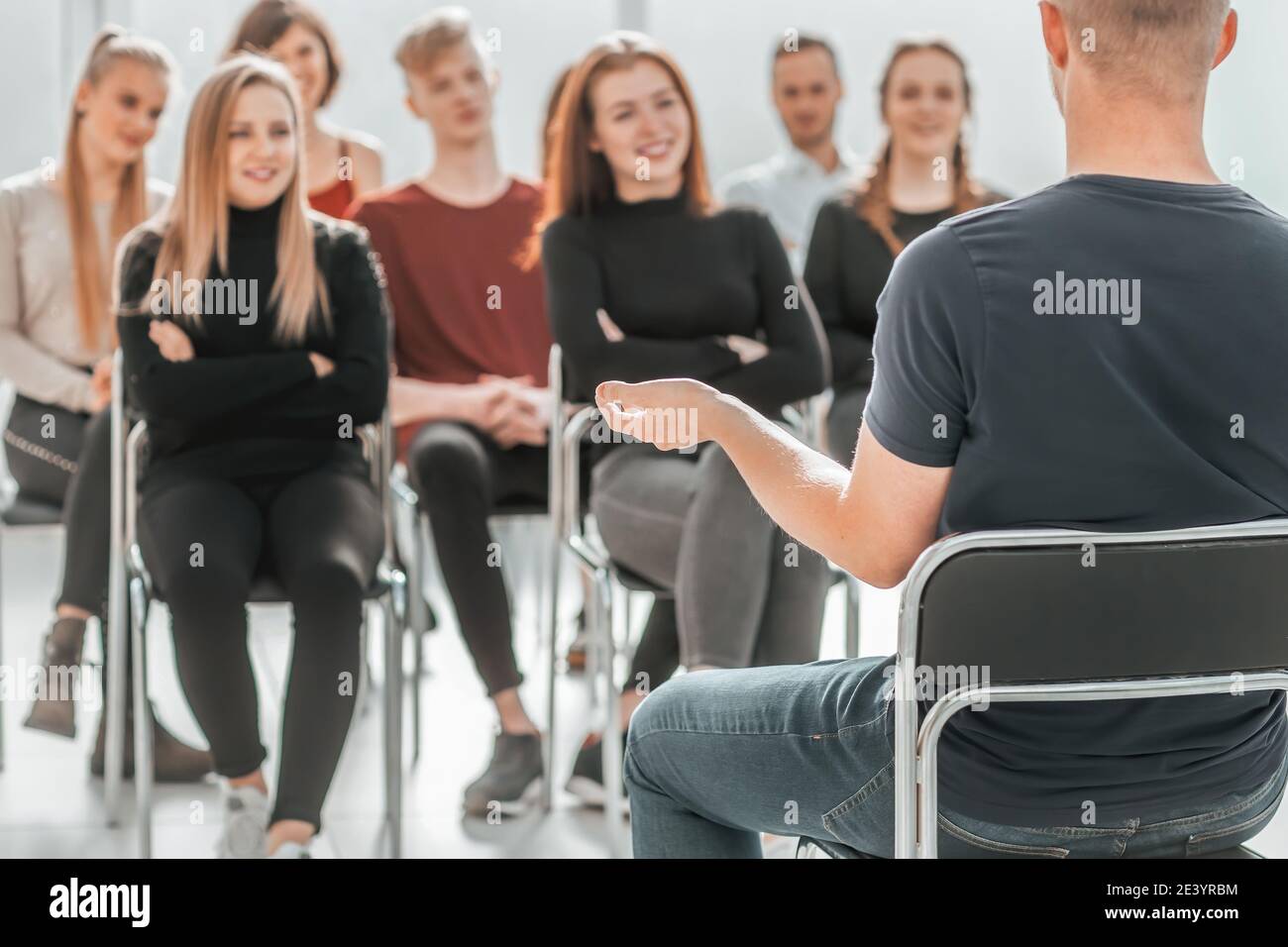 speaker and a group of young people sitting in a conference room Stock ...