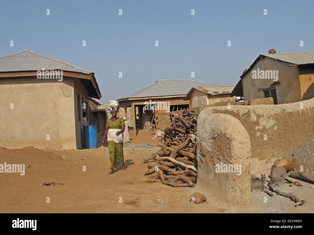 lady with pots on head walking through village  Larabanga Village, Ghana          February Stock Photo