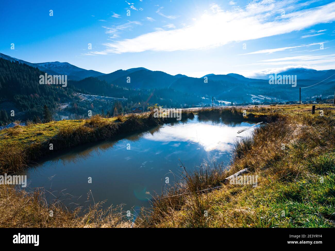 Shiny little puddle on a spring green field on the extraordinary hills ...