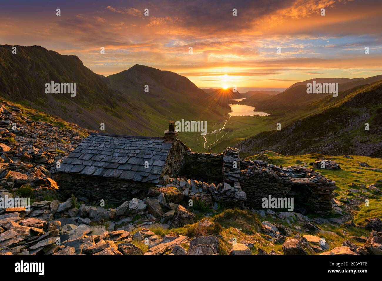 Old mountain shelter Warnscale Bothy with beautiful sunset over Buttermere in the Lake District, UK. Stock Photo
