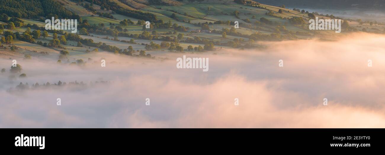 Beautiful misty morning with cloud inversion in Peak District valley. Stock Photo