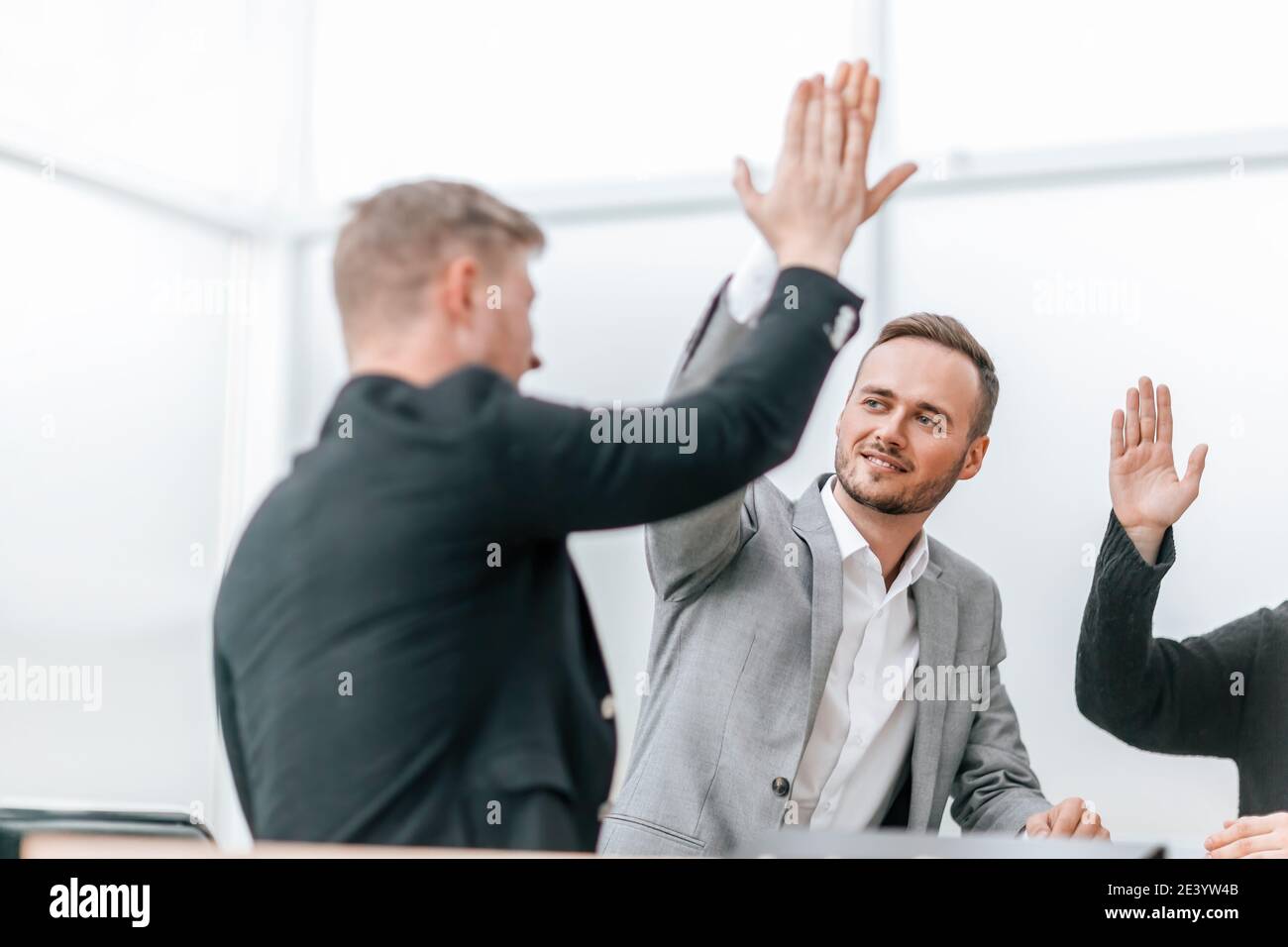 young employees giving each other a high five Stock Photo