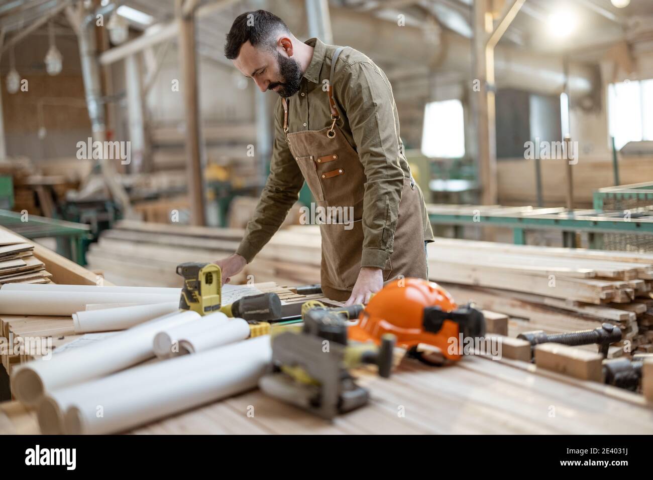 Handsome carpentry worker in the joinery manufacturing Stock Photo