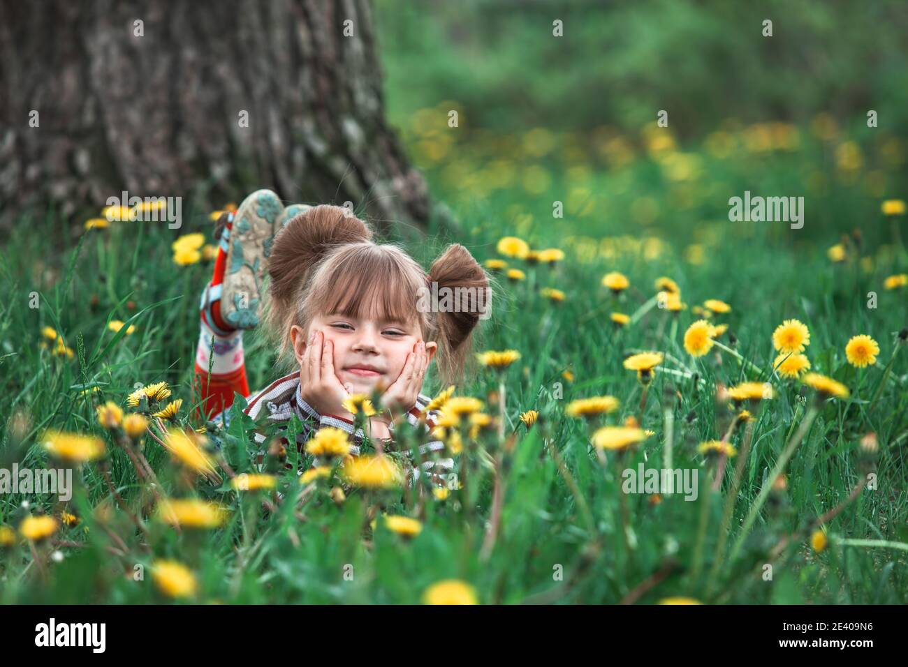 Little girl lying in the green grass in park Stock Photo - Alamy
