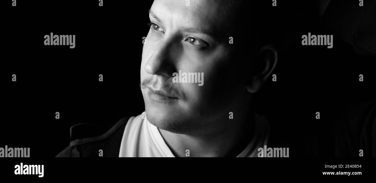 Close-up black and white portrait of a strong, confident male person. Wide, banner format Stock Photo