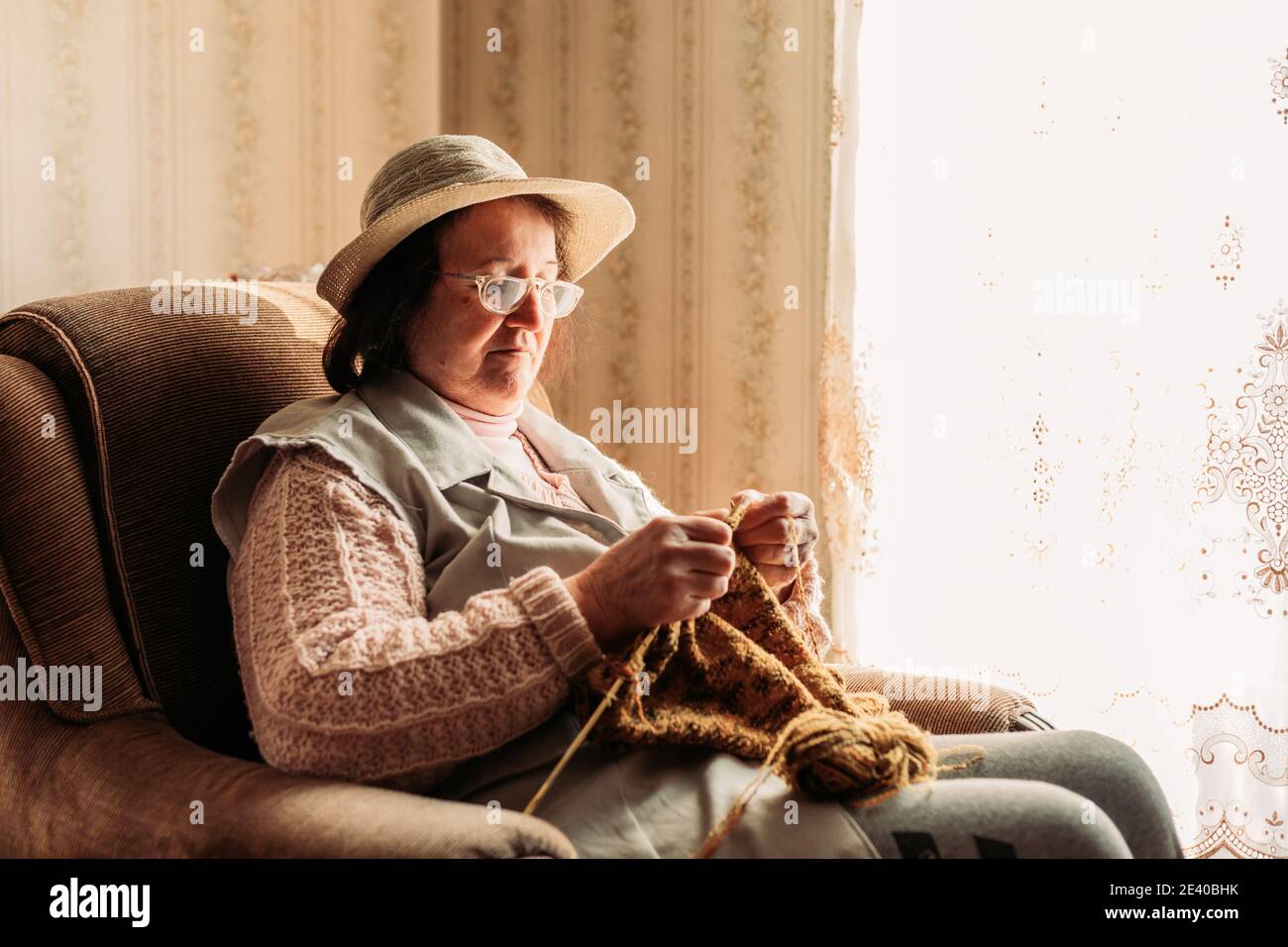 Elderly woman knitting sweater for her grandchildren Stock Photo - Alamy