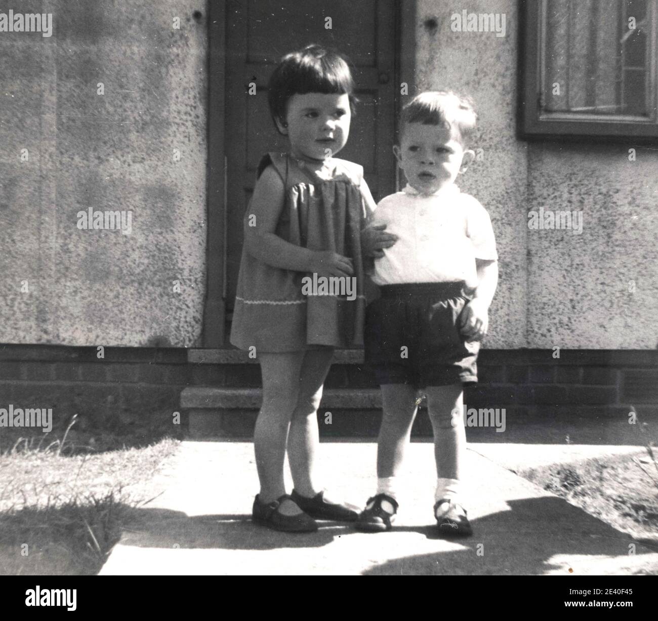 Girl and a boy outside prefsbricated house, Leeds, !960's Stock Photo